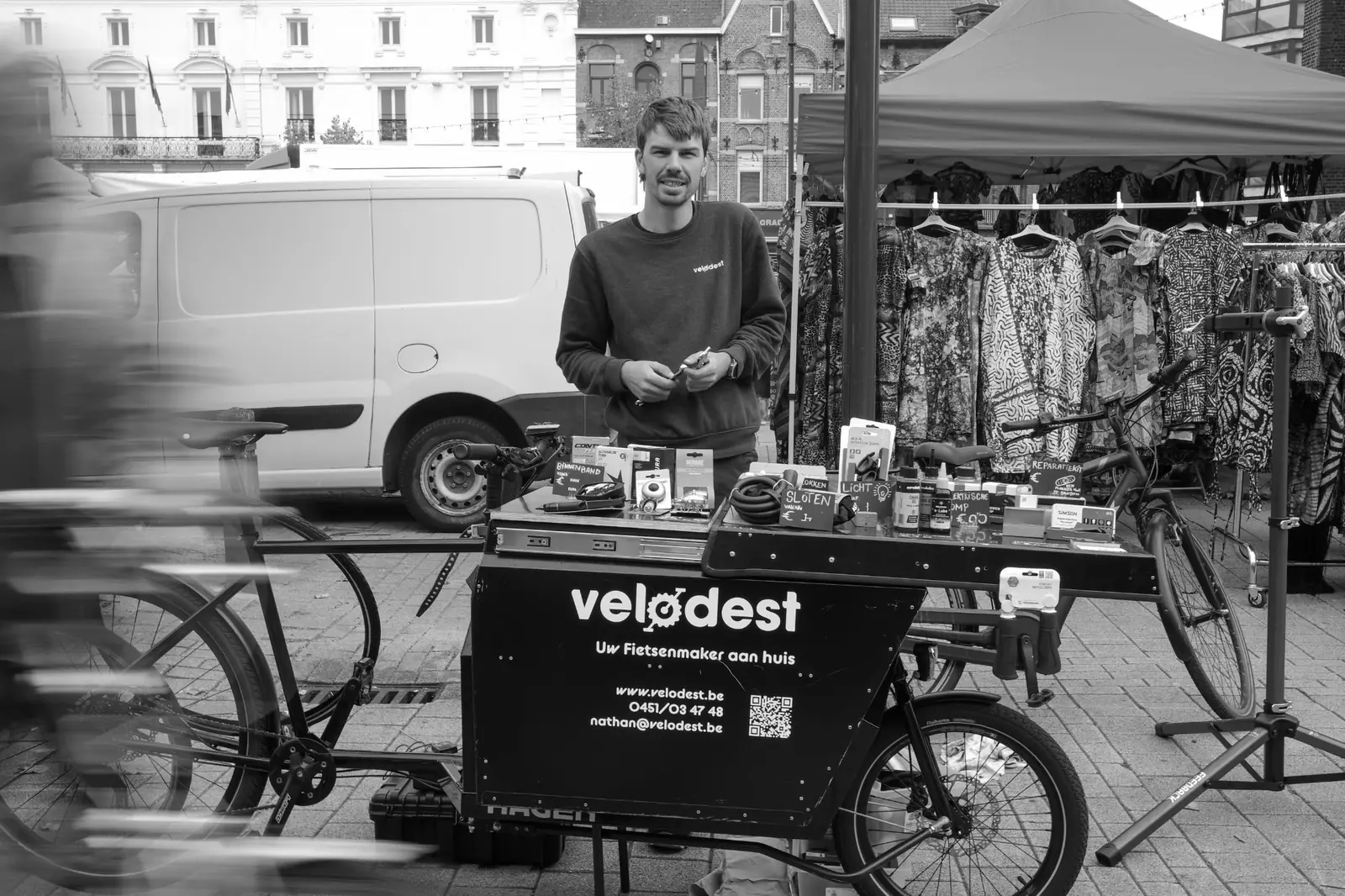 Nathan aan zijn marktkraam, met de Velodest-bakfiets en onderdelen uitgestald